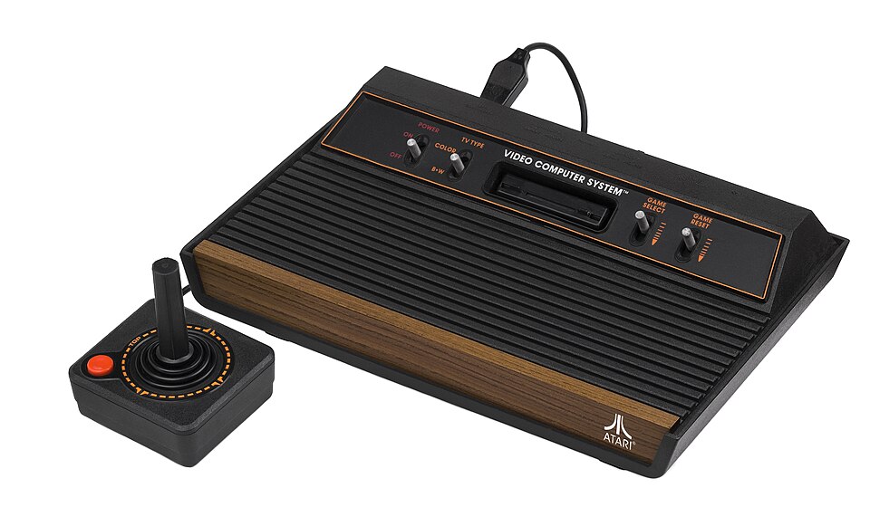 An Atari 2600 console with woodgrain trim and a joystick