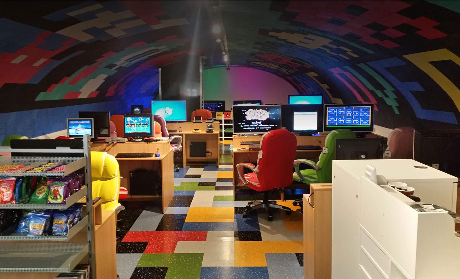 Inside Game Over in Old Portsmouth — gaming stations under a vaulted, pixel-patterned ceiling