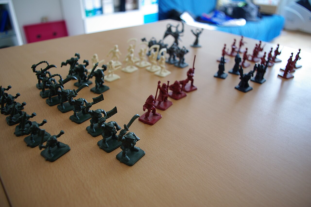Rows of HeroQuest plastic miniatures: heroes, orcs, skeletons and monsters
