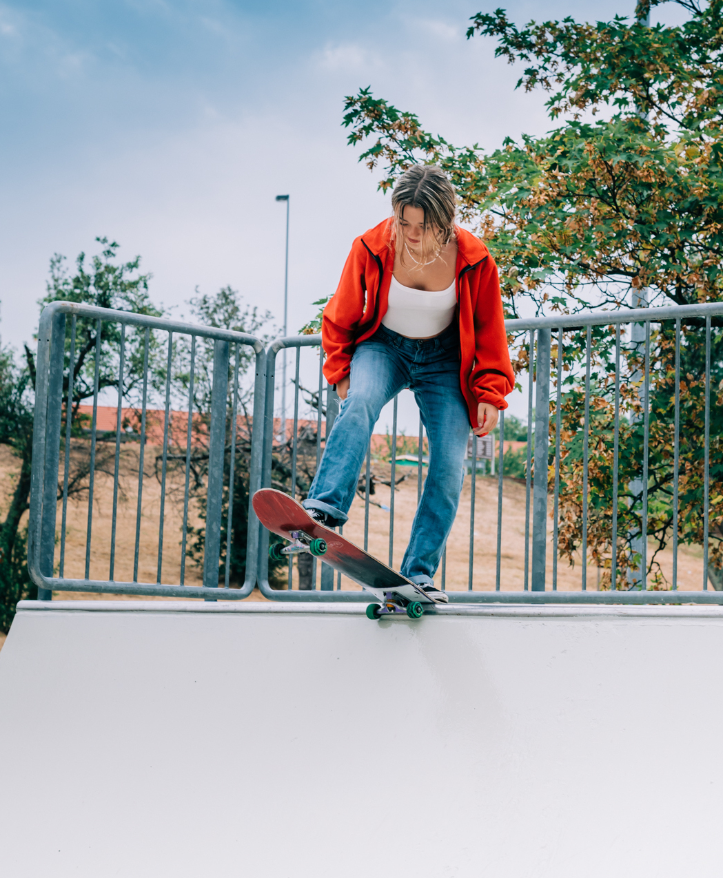 A skateboarder dropping in on a real half-pipe at a skate park opening