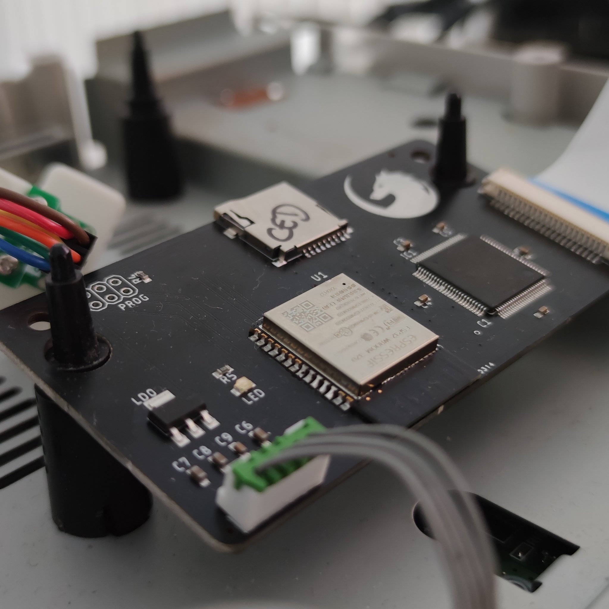 Close-up photo of a Fenrir ODE board installed inside a Sega Saturn, showing the microSD slot and Wi-Fi module